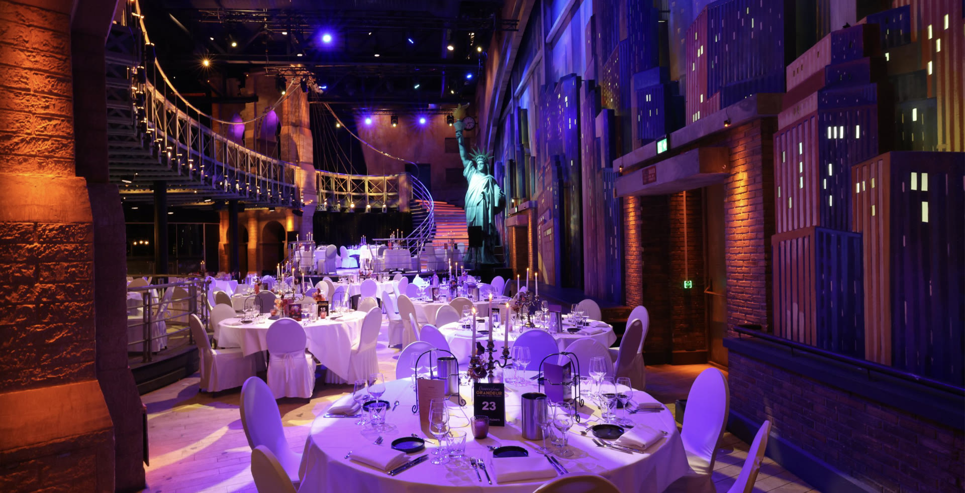 Dinnershow Grandeur - feestelijk gedekte tafels in het New York-decor van de zaal